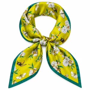 Foulard jaune à fleurs blanches et papillons, bordure vert canard, noué sur fond blanc
