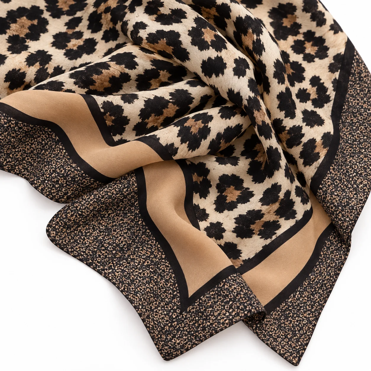 Détail du motif léopard noir sur fond beige et des bordures caramel du foulard